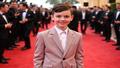 Millie Bobby Brown on a red carpet, charts behind her predicting rising strollers, houseplants, and question marks.