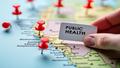 Close-up of a public health map with red pins and a hand holding a vaccine card, ominous yet ridiculous.