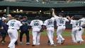 Mariners players drenched in something that might be champagne or sky, grinning like people who finally found parking near the ballpark.