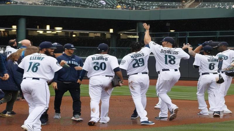 Mariners players drenched in something that might be champagne or sky, grinning like people who finally found parking near the ballpark.