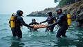 Divers in neon wetsuits hoist a sunken amphitheater fragment from choppy waters.