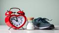 A heart-shaped alarm clock blaring beside a salt shaker, unopened running shoes, and an untouched annual checkup reminder.