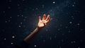 A luminous hand floats among the stars, posing like a cosmic model.
