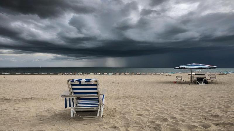Empty Crimean beach loungers under brooding clouds, lifeguard chair scanning horizon, while officials gesture at nothing like it’s evidence.