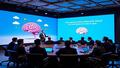 Microsoft executive in a brain-shaped conference room delivers cautionary slides.