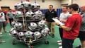 Trainers wheel a mountain of tape and ice past Patriots and Steelers helmets, as a clipboard labels everything 'questionable' including the Gatorade.