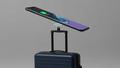 Galaxy S26 hovering over a magnetic charger as a tiny feature icon waves goodbye with a suitcase.