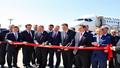 Ceremonial ribbon-cutting at a crowded airport gates as officials toast resumed direct air links between two giants.