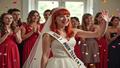Hayley Williams in a bridal sash, confetti midair, pressing play on a speaker while bridesmaids gasp like a jury hearing the verdict.