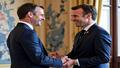 Macron and Lecornu exchange an invisible baton at the Élysée, a ceremonial GPS recalculating in the corner as aides stack folders by color and immediate existential urgency.