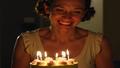 Ethel Caterham smiles softly as a candlelit cake glows, embodying the phrase at her own pace.