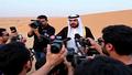 Desert press conference featuring a Hamas spokesperson announcing a 'Pause for Peace' amid swirling media cameras.