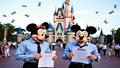 Investors in mouse ears clutch spreadsheets outside a Disney castle, holding 'Show Us Receipts' signs as dollar-bill confetti falls and security pretends this is a character meet-and-greet.