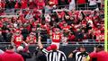 Freeze-frame of Mahomes’s post-TD moment from sideline, refs nearby, fans mid-cheer, arrows circling the ambiguous gesture.